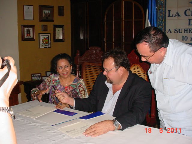 La doctora Ibarra, el Alcalde, firman convenio y observa el dr. Norman Miranda Castillo, Presidente del Tribunal de Apelaciones